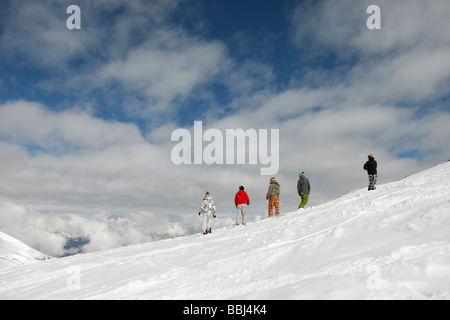 Gemischte Gruppe von Skifahrer und Snowboarder treffen auf einem Bergrücken abseits der Pisten im Skigebiet Les Deux Alpen, Alpen, Frankreich Stockfoto