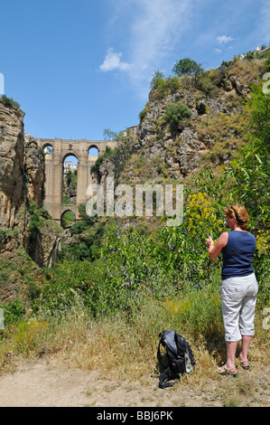 Touristen, die ein Foto von el Puente Nuevo oder die neue Brücke und El Tajo Schlucht von Ronda Spain Stockfoto