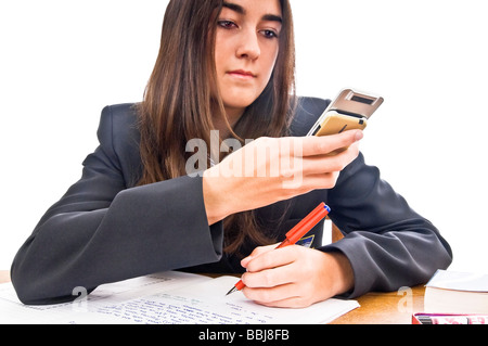 Horizontale Bildniss eines attraktiven Teenager Schulmädchen mit ihrem Handy SMS-Nachrichten, während ihre Hausaufgaben Stockfoto