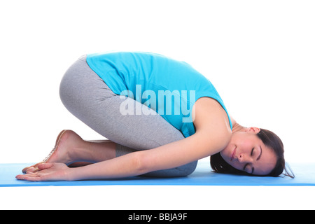 Brünette Frau auf eine Yoga-Matte in der Balasana Lage auch bekannt als die Childs Pose auf einem weißen Hintergrund isoliert Stockfoto