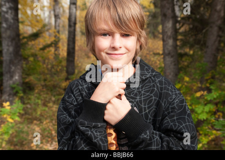 10 Jahre alter Junge mit Gehstock auf Spuren im Wald, See Katherine Riding Mountain National Park, Manitoba Stockfoto