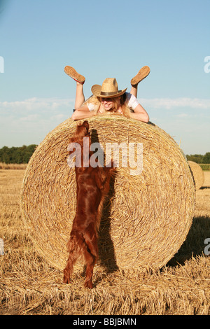 Frau und Irish Red Setter Hund auf Stroh Stockfoto