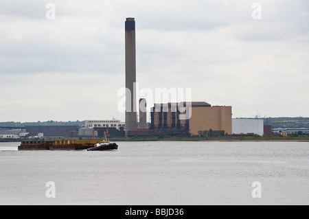 Ein Schlepper abschleppen Lastkähne auf der Themse vorbei Littlebrook Power Station. Stockfoto