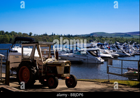 Ein Traktor schleppen ein Boot aus dem Wasser an Cameron House Marina Loch Lomond, Schottland Stockfoto