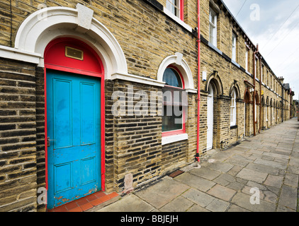 Reihenhäuser auf eine typische Straße in die World Heritage Site Saltaire, Bradford, West Yorkshire, England Stockfoto