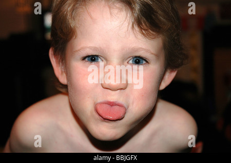 Ein kleiner Junge seine Zunge in die Kamera herausziehen Stockfoto