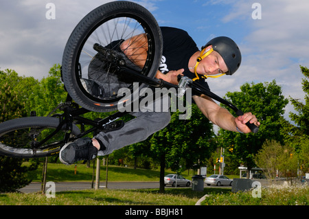 Airborne urban BMX Bike Reiter in einer Luft, die Tischplatte über den lokalen Verkehr an einem Toronto City Skatepark Stockfoto