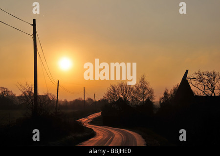 Roter Sonnenaufgang über eine frostige Spur in der Landschaft, in der Nähe von Great Chart, Ashford, Kent, Großbritannien Stockfoto