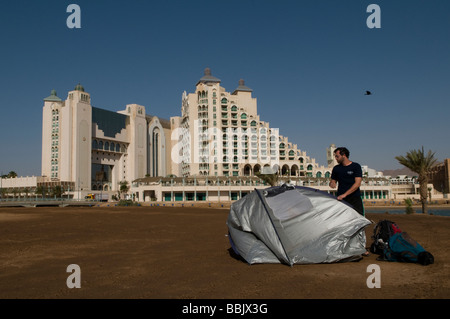 Ein junger Mann ein Zelt vor Hotel Komplex in Eilat Seeküste Südisrael einrichten Stockfoto