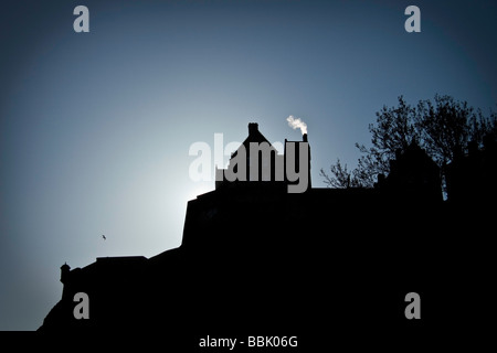 Die Silhouette des Edinburgh Castle vor blauem Himmel, eine Korona von Licht hinter das Schlossgebäude Stockfoto