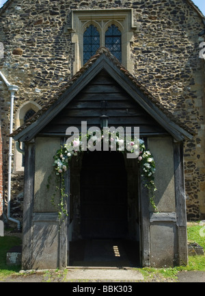 Blumenschmuck für Hochzeitsgirlanden wurde über der Tür zur St. James Church ausgestellt. Shere Surrey England 2009 2000s UK HOMER SYKES Stockfoto