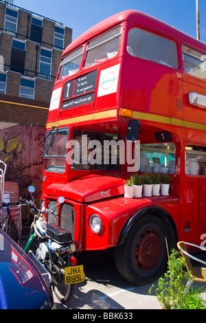 Brick Lane, Shoreditch, East End, Doppeldecker rot bus jetzt die Wurzel - master vegetarischen Café-Restaurant mit Töpfe mit Kräutern Stockfoto