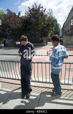 Zwei Jungs und ihre Handys, UK 2009 London Stockfoto
