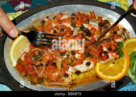 Bobby Flay inspiriert Fisch Roman geb. Snapper Filet Entrée mit gewürfelten Tomaten Zwiebeln Basilikum Schalotten und Kapern Stockfoto