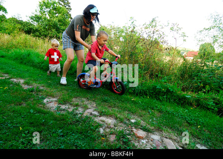 Kleiner Junge mit zwei Frau Mütter Fahrrad fahren lernen Stockfoto