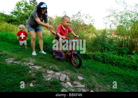 Kleiner Junge mit zwei Frau Mütter Fahrrad fahren lernen Stockfoto