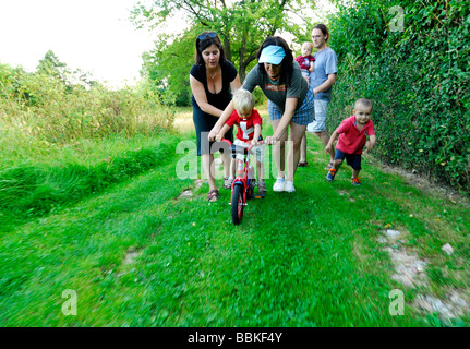 Kleiner Junge mit zwei Frau Mütter Fahrrad fahren lernen Stockfoto