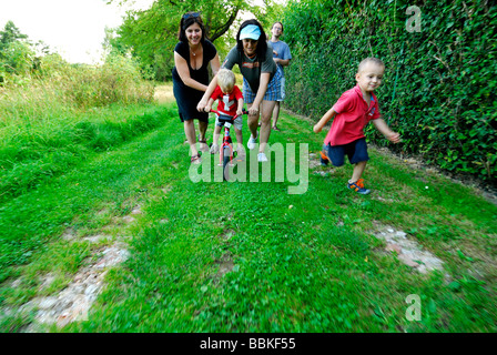 Kleiner Junge mit zwei Frau Mütter Fahrrad fahren lernen Stockfoto