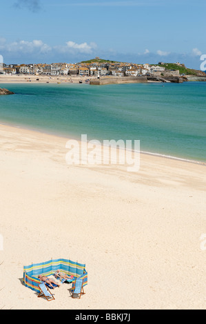 Zwei Sonnenanbeter teilen einen leere Porthminster Strand in St. Ives, Cornwall Stockfoto