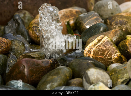 Wasser-Brunnen über Kiesel Stockfoto