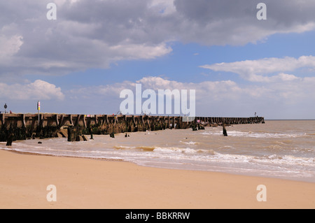 Alten Fäulnis Peir unterstützt am Strand von Walberswick Suffolk mit Betonmauer Struktur hinter Stockfoto