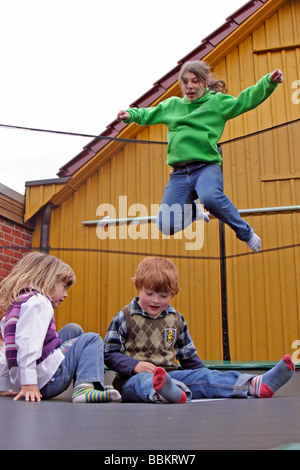 drei Kinder springen auf einem Trampolin Stockfoto