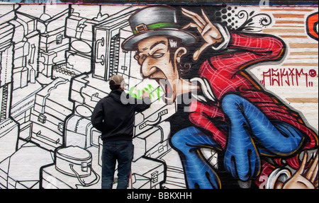 Graffiti-Künstler arbeiten am Design in Bacon Street Shoreditch London UK Stockfoto