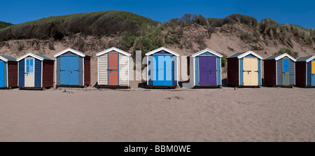 eine Reihe von Strandhütten an einem Sandstrand mit Dünen hinter Stockfoto