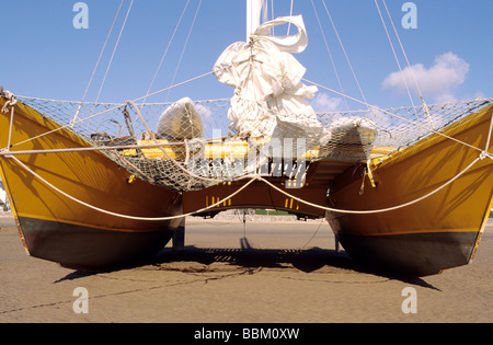 Leuchtend gelbe Catermerang Segelboot, Yacht, am Strand in Appledore, North Devon Stockfoto