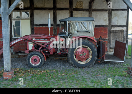 Traktor in der Scheune auf einem eigenen Familienbauernhof geparkt Stockfoto