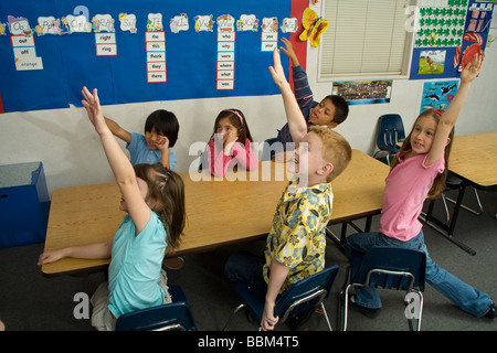 5-6 Jahre alten Schüler begeisterte junge ethnische Vielfalt ethnisch vielfältigen multikulturellen interracial Anhebung Inter Hände Klasse USA Herr © Stockfoto