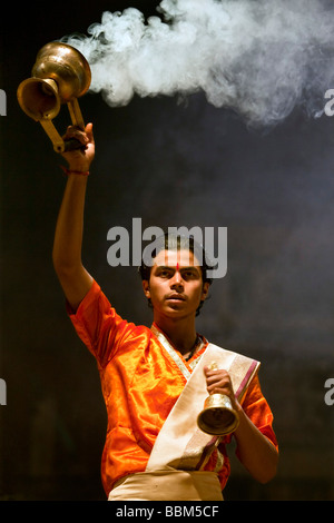 Junge indische männliche Priester darstellende Puja (Agni Pooja) am Dashashwamedh Ghat, Varanasi, Indien Stockfoto