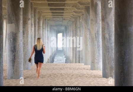 Frau zu Fuß unter dem Pier Huntington Beach Orange County in Kalifornien Stockfoto