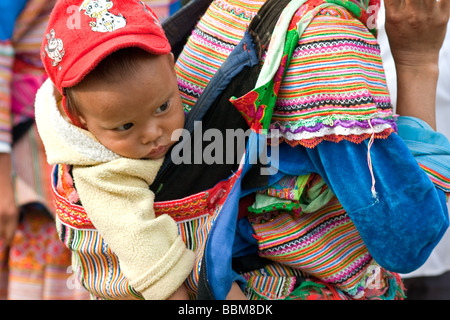 Blume h ' Mong Tribal Frau mit Kind die traditionelle Lebensweise in Bac Ha Markt, Bac Ha, Vietnam Stockfoto