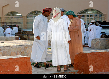 Einheimische Männer tragen Dishdasha, das traditionelle omanische Kleidungsstück auf dem Gelände der Ziege zu vermarkten, Nizwa, Sultanat von Oman Stockfoto