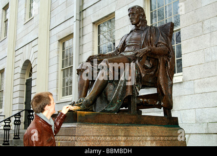 Student an der Statue von John Harvard von Daniel Chester French, die Berührung des Schuhs Glück bei den Prüfungen, Harvard University bringen. Stockfoto
