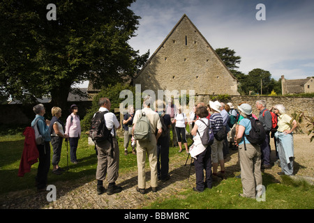 Eine Gruppe von Rentnern Blick auf eine historische Kirche in den Cotswolds, Eastleach Turville, Gloucestershire, Großbritannien Stockfoto