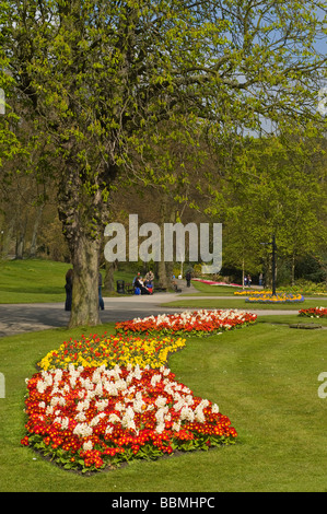 dh Valley Gardens HARROGATE NORTH YORKSHIRE Leute auf Bank bunte Blume Display und Gartenwege Stockfoto