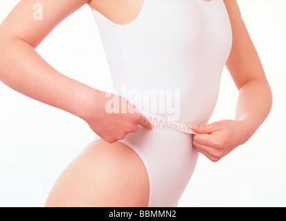 Mittelteil einer Frau, die ihre Taille messen Stockfoto