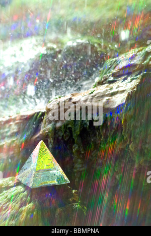 Glaspyramide mit farbigen Lichtstrahlen im Wasserfall Stockfoto