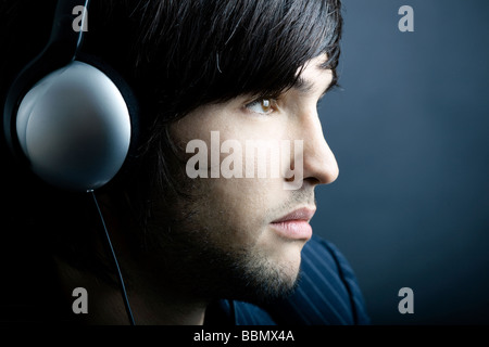 Young Man Musikhören mit Kopfhörer Stockfoto