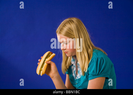 Porträt eines jungen Mädchens auf der Suche mit Ekel an einem Hotdog Profil lustig Myrleen humorMR © Pearson Stockfoto