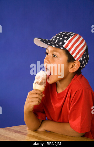 Porträt der jungen hispanischen junge 7-9 jährige tragen Sterne und Streifen Hut lecken Eiswaffel, 4. Juli Feier ausgeschnitten Herr © Myrleen Pearson Stockfoto