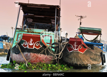 Zwei Handel Boote aus Holz, traditionelle bemalten Bögen, wachsamen Augen und Anker, zusammengebunden, schwimmend auf Mekong River, mich Stockfoto