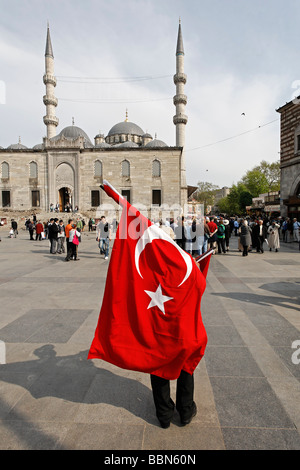 Straßenverkäufer trägt große türkische Nationalflagge, Platz vor der neuen Moschee, Yeni Cami, Eminoenue, Istanbul, Türkei Stockfoto