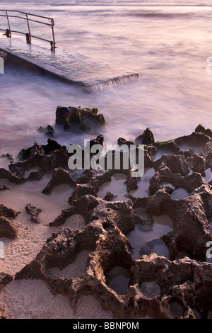 Eine lange Belichtung Wellen Waschen über eine Abschussrampe. Mettam Pool, Perth Stockfoto