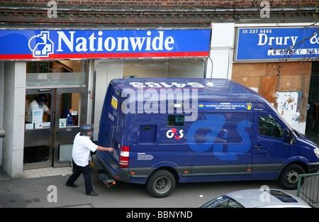 Eingabe der Rückseite einer Gruppe 4 Sicherheit Wachmann van mit Geld aus der bundesweiten Bausparkasse. Stockfoto