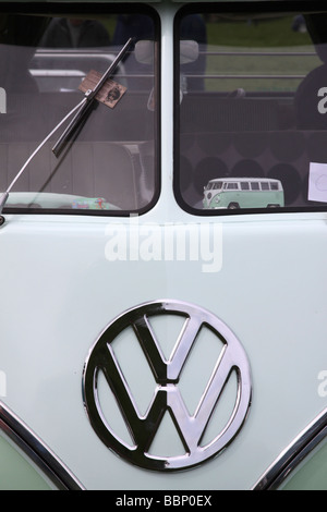 Vorderseite des grün-weißen VW Wohnmobil zeigt das VW-Logo und ein Modell VW Camper in der Frontscheibe Stockfoto