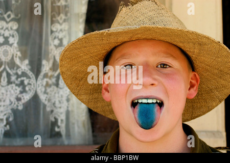 Reliefierten Knabe in blau.  Sommersprosse konfrontiert und liebenswert dieser all American Boy ragt seine blauen Lutscher gebeizt Zunge für die Kamera. Stockfoto