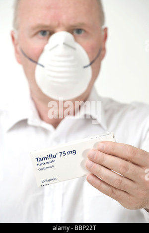 Mann mit einer Maske und Tamiflu-Paket Stockfoto